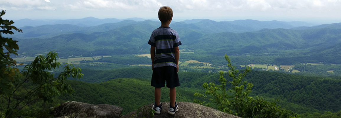 child standing at mountain overlook